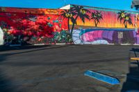 the painted wall in this parking lot is full of different colors and shapes on it