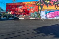 an empty parking lot is painted with colorful graffiti art and palm trees on the sides