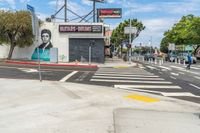 an empty street with a woman's face painted on the side of it with some signs