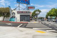 an empty street with a woman's face painted on the side of it with some signs