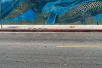 an elephant and baby whale painted on a wall near a street corner for a walk