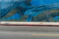 an elephant and baby whale painted on a wall near a street corner for a walk