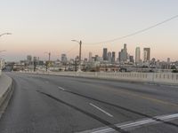 two yellow arrows are on a gray street near the city skylines in this picture