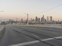 two yellow arrows are on a gray street near the city skylines in this picture