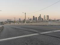 two yellow arrows are on a gray street near the city skylines in this picture