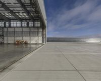 an airplane is parked inside of an enclosed building with windows overlooking water and mountains below