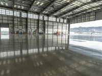 several workers work to clear out tarmac from the inside of the hangar area of a hangar