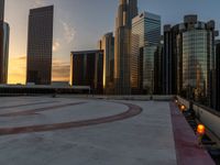 the sun is setting in downtown on the roof of an office building with tall buildings