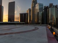 the sun is setting in downtown on the roof of an office building with tall buildings