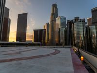 the sun is setting in downtown on the roof of an office building with tall buildings