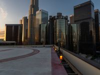 the sun is setting in downtown on the roof of an office building with tall buildings