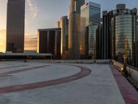 the sun is setting in downtown on the roof of an office building with tall buildings