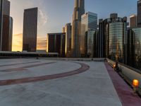 the sun is setting in downtown on the roof of an office building with tall buildings