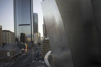 a city view with tall buildings and people on a street below and some cars on the road behind