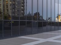 reflection in the window wall of a large office building with windows reflecting a city street