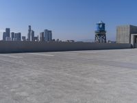 a skateboarder performing tricks on top of an old building on a roof, with tall buildings behind him