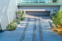 an empty public space with several benches sitting below the trees and planters along side