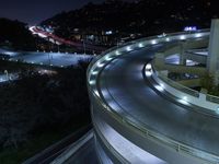 a long exposure shot shows an empty intersection at night with cars on the road and mountains