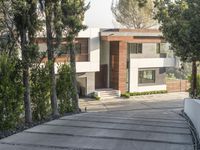 the exterior and landscape of a modern house in los angeles, california with stone and wood