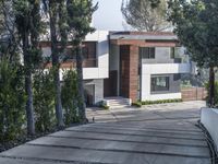 the exterior and landscape of a modern house in los angeles, california with stone and wood