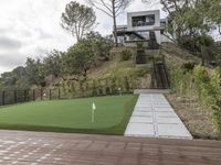 a patio with a wooden deck and artificial turf for putting a green putt on it