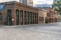 the large brick building has two rows of windows on one side and several windows on the other