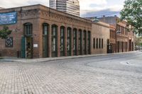 the large brick building has two rows of windows on one side and several windows on the other