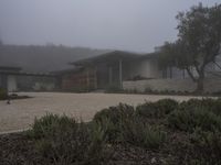 house with driveway, concrete and gravel driveway in foggy landscape area outside of residential residence