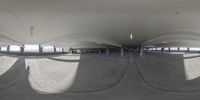 a view of inside of an indoor parking space with curved ceilings and multiple circular lights