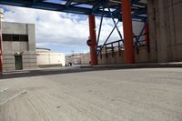 a man is sitting on the side walk of a building by himself with a skateboard in his hand