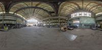 a fish eye view shows the inside of an industrial building with multiple windows and a concrete floor