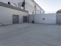 the front entrance of an industrial building with a work crane and large metal security gate