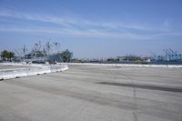 an empty parking lot surrounded by industrial docks and seaplanes are seen here in this image