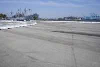 an empty parking lot surrounded by industrial docks and seaplanes are seen here in this image