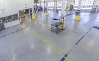 view of the inside of a factory showing equipment for painting, including the flooring, and some shelves,