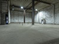 an empty warehouse with white walls and cement floors in it's empty space with tall columns