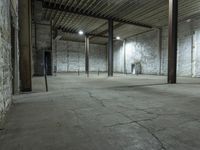 an empty warehouse with white walls and cement floors in it's empty space with tall columns