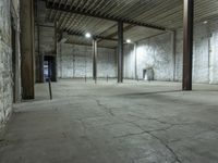 an empty warehouse with white walls and cement floors in it's empty space with tall columns