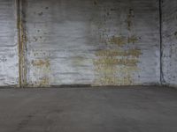 an empty room with a very yellow and peeling paint on the wall and floor and a brick back