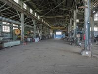 an empty industrial room with exposed ceiling and windows in the background is full of industrial equipment