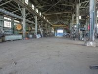 an empty industrial room with exposed ceiling and windows in the background is full of industrial equipment