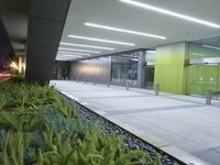the interior of an empty building lit up at night time as people walk by it