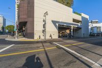 there is a white building on this street corner with a green roof and a bicycle stand by it