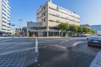 there is a white building on this street corner with a green roof and a bicycle stand by it