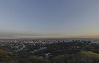 the town is in the distance with no clouds above it as the sun rises on the hill