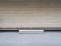 a white bench sitting on top of a floor near a brick wall near a fire hydrant