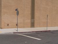 a stop sign sits in the middle of an empty street corner next to a brick building