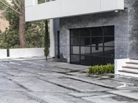 the exterior and landscape of a modern house in los angeles, california with stone and wood