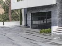 the exterior and landscape of a modern house in los angeles, california with stone and wood