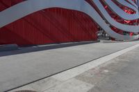 there is an american flag on the side of this building by the sidewalk area,